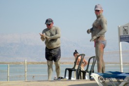 Отдыхающие мажутся грязью на Мертвом море.